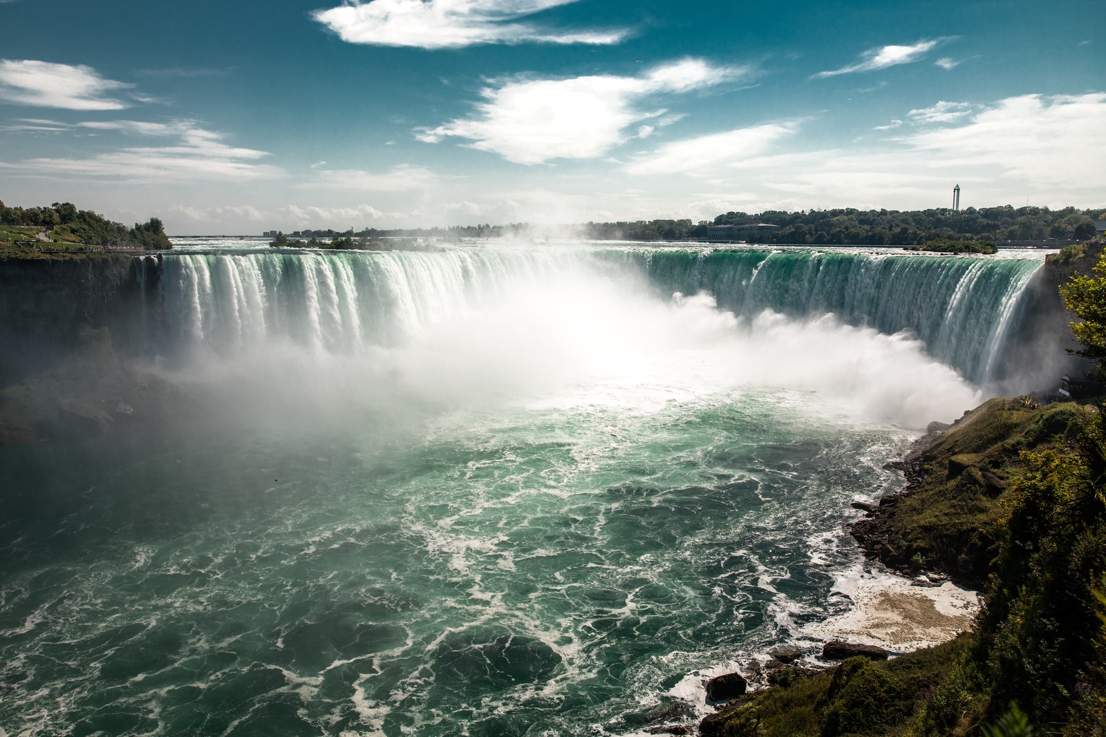 water falls under blue sky during daytime